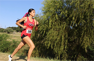 female cross country athlete running in a meet